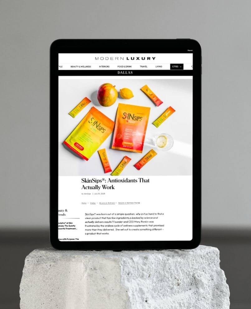 Tablet displays Modern Luxury Dallas article featuring SkinSips antioxidant drink.