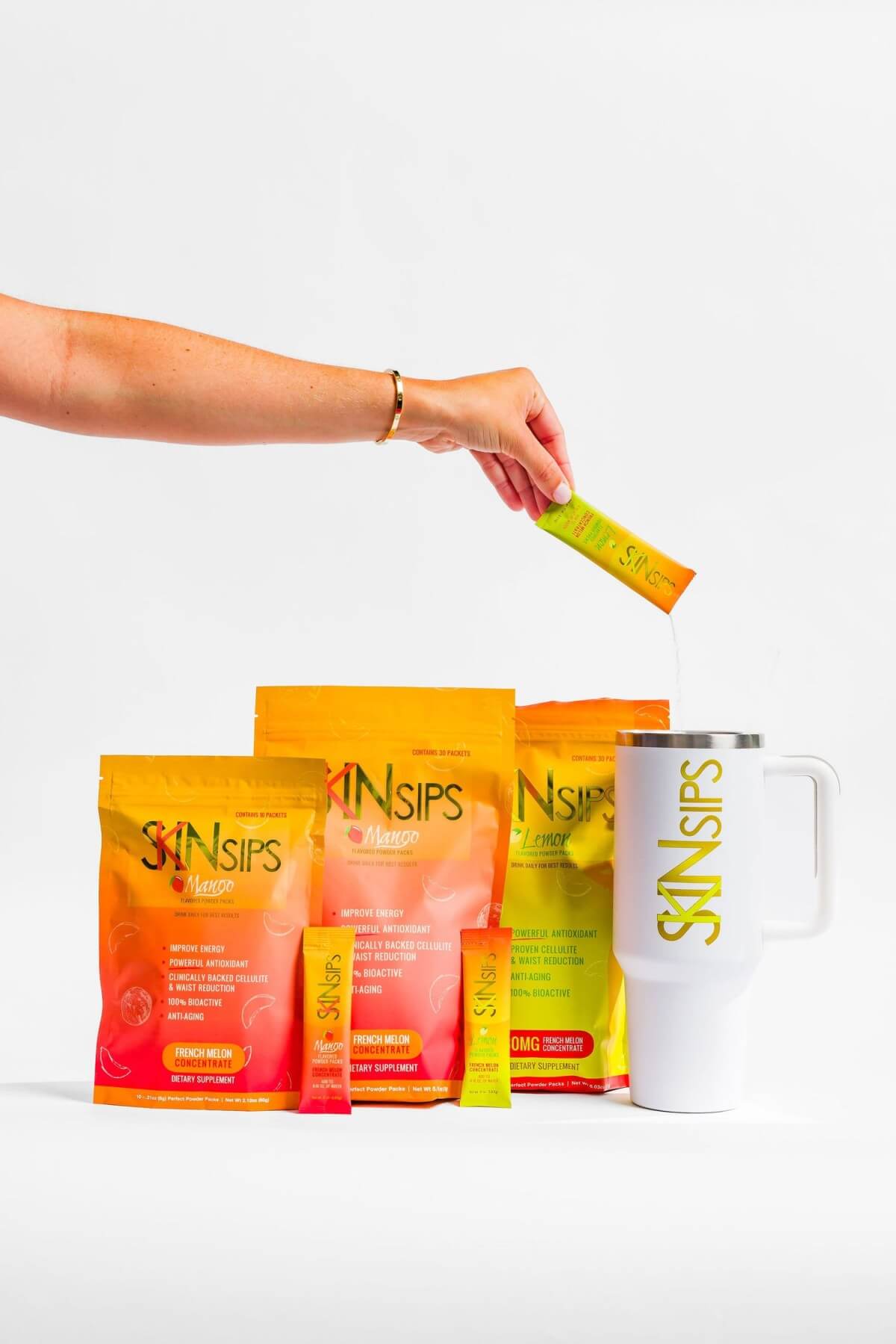 SkinSips mango and lemon pouches with stick pack poured into branded tumbler.